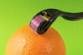 Derma roller for medical micro needling therapy with orange. Royalty Free Stock Photo