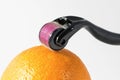 Derma roller for medical micro needling therapy with orange. Royalty Free Stock Photo