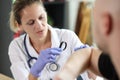 Dermatologist conducts medical examination on skin of male patient with magnifying glass in clinic. Royalty Free Stock Photo