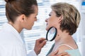 Dermatologist examining mole with magnifying glass Royalty Free Stock Photo