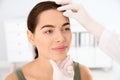 Dermatologist examining patient`s face in clinic