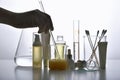 Dermatologist formulating and mixing pharmaceutical skincare, Cosmetic blank bottle containers and scientific glassware.