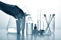 Dermatologist formulating and mixing pharmaceutical skincare, Cosmetic bottle containers and scientific glassware.