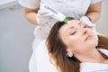 Dermatologist performs a facial cleaning procedure with an ultrasonic machine