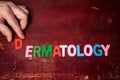 DERMATOLOGY. Text from colorful alphabet letters on wooden background