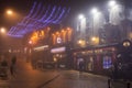 Derry City Street in a Foggy Night with Bars and Christmas Lights.