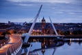 Derry, Ireland. Illuminated Peace bridge in Derry Londonderry, City of Culture, in Northern Ireland with city center at Royalty Free Stock Photo