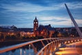 Derry, Ireland. Illuminated Peace bridge in Derry Londonderry, City of Culture, in Northern Ireland with city center at Royalty Free Stock Photo