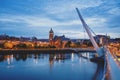 Derry, Ireland. Illuminated Peace bridge in Derry Londonderry, City of Culture, in Northern Ireland with city center at Royalty Free Stock Photo