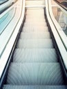 Descending escalator moving stairs in city shopping mall or business office building. Abstract concept of direction destination mo Royalty Free Stock Photo