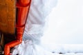 The descent from the roofs of the snow. A large snowdrift of melting snow with icicles rolls down from the roof