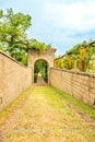 The descent between the stone walls to the park gates in the form of an arch.Vertical photo Royalty Free Stock Photo