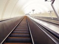 Descent into the tunnel stereo escalator stairs light from below. Modern tunnel escalator electronic system moving vintage style,