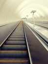 Descent into the tunnel stereo escalator stairs light from below. Modern tunnel escalator electronic system moving vintage style,