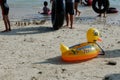 Lampung, Indonesia - May 15, 2022: Yellow duck swim tire for kids washed up on the beach