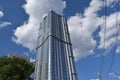 Skyscraper in the city against the blue sky with clouds on a summer day