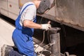 welding work. A worker in overalls and a protective mask welds the flange to the pipe on the street. Repair work gorodskih Royalty Free Stock Photo