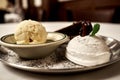 Sweet dessert assorted with icecreams topped with chocolate pecan on a plate sprinkeld with sugar powder