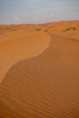 Desert contrast of orange colored sand and bright blue sky in the rolling hills in Ras al Khaimah, in the United Arab Emirates Royalty Free Stock Photo