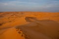 Desert contrast of orange colored sand and bright blue sky in the rolling hills in Ras al Khaimah, in the United Arab Emirates Royalty Free Stock Photo