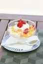 Desert with cream-cheese and fruits on the wooden table