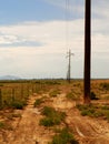 Desert dirt road by telephone poles Royalty Free Stock Photo