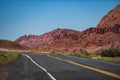 Desert highway at sunset, travel concept, USA. Landscape with orange rocks, sky with clouds and asphalt road in summer Royalty Free Stock Photo
