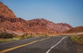 Desert highway at sunset, travel concept, USA. Landscape with orange rocks, sky with clouds and asphalt road in summer Royalty Free Stock Photo
