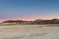 The glowing sky of sunset over the desert landscape of the Bisti Badlands of New Mexico