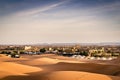 Desert landscape with Moroccan palace. Arabian nights hotel. Sand dunes of Erg Chebbi