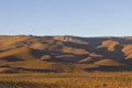 Desert mountains with long shades at sunset.