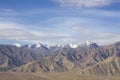 A desert mountains with snowy peaks under a blue sky with white clouds Royalty Free Stock Photo