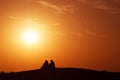 Desert nomads on the crest of a barchan at sunset Royalty Free Stock Photo