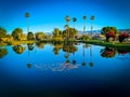 Desert oasis  campground lake pond with palm trees and shadow hills mountains beyond reflection reflecting in water Royalty Free Stock Photo