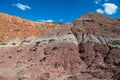 A desert peak with colorful layers of bare, eroded earth