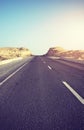 Desert road at sunset, front focus on asphalt, color toning applied, Egypt Royalty Free Stock Photo
