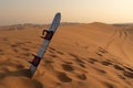 Desert safari tour in UAE. Snowboard used for sand boarding standing inserted in sand dune