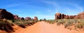 Desert sand road leading through Monument Valley in Arizon / Utah - beautiful sunny day