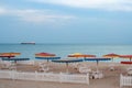 Desert seascape with white deck chairs under colorful beach umbrellas Royalty Free Stock Photo