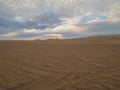 Desert sunset, the light glows over the gold sand under the golden blue sky