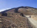 Desert volcanic landscape with lonely hiker climbing on volcano pico del teide with Huevos del Teide Eggs of Teide accretionary