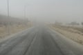 desert, wilderness, wasteland. Driving on gray and heavy foggy day on country road. Poor visibility condition. Royalty Free Stock Photo