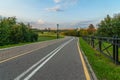 Deserted asphalt path in the city park in the early evening Royalty Free Stock Photo