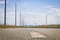 Deserted asphalt road with road markings and a number of lighting lamps on the side of the road. Royalty Free Stock Photo