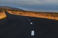 A deserted asphalt road running away into the hills. Iceland. The spirit of travel and adventure. Royalty Free Stock Photo