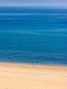 Deserted beach with brilliant blue sea Royalty Free Stock Photo