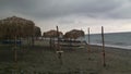 Deserted beach, cloudy weather, sand and cane umbrellas, no people