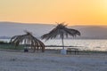 Deserted beach. Kineret lake. Old palm straw umbrella.