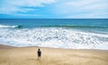Deserted beach and lone watching man, person stands alone on sea sand shore Royalty Free Stock Photo