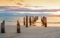 Deserted beach and and the remains of the ruined pier in the water Royalty Free Stock Photo